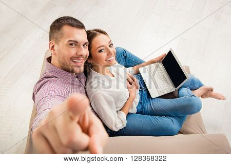 Top View Of Happy Man And Woman Sitting  On The Sofa With Laptop, Man Touching Camera