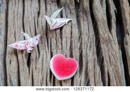 Origami couple paper crane and heart on wood