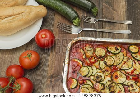 zucchini gratin , baked , with tomatoes,zucchinis and fresh tomatoes on the table