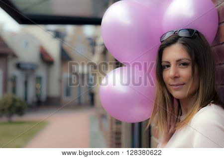 Beautiful and cute girl with balloons looking at the camera