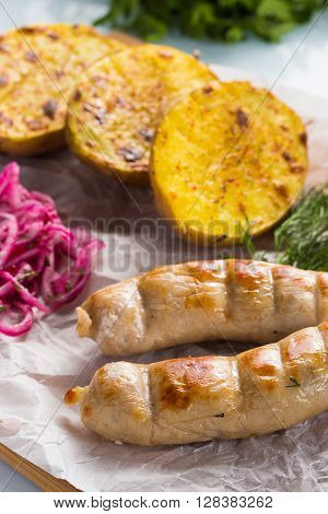 macro meat kupaty with fries and greens on white plate. potato