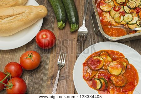 zucchini gratin , baked , with tomatoes,zucchinis and fresh tomatoes on the table