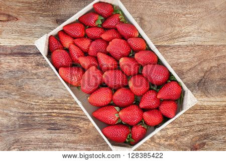 Fresh strawberries in a box on a wooden table