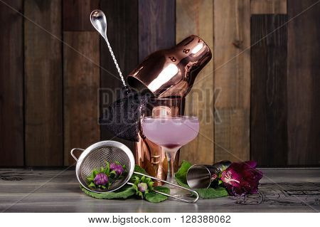 Set of bar accessories and ingredients for making a cocktails arranged on a wooden background with flowers