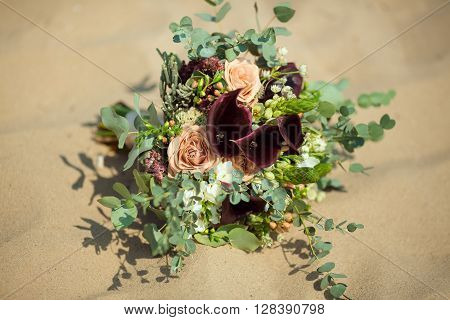 Bride's Pink Orange and White Wedding Bouquet Laying on Sand