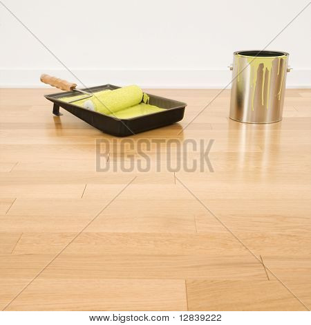 Nature morte de rouleau dans le bac avec de la peinture peut être téléchargé sur plancher en bois.