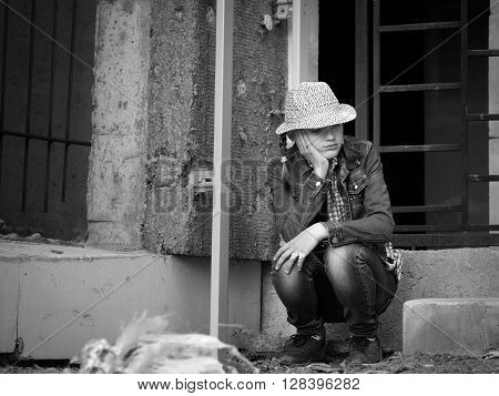 Girl teenager in an abandoned construction site. Ruins. Social, black - white. Concept - stress, teen complexes. Vagrancy, escape from home