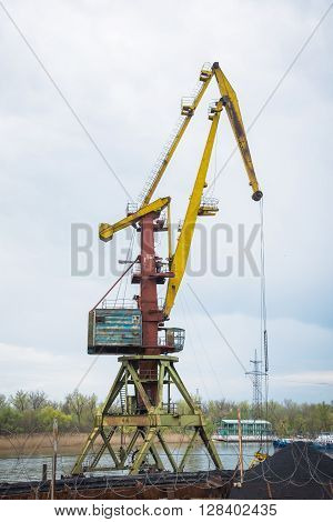 port crane behind the barbed wire on the bank