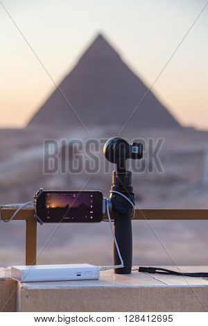 CAIRO, EGYPT - FEBRUARY 2, 2016: iPhone on Osmo device and battery pack set up to record timelapse of The Great Pyramid of Giza at sunset.