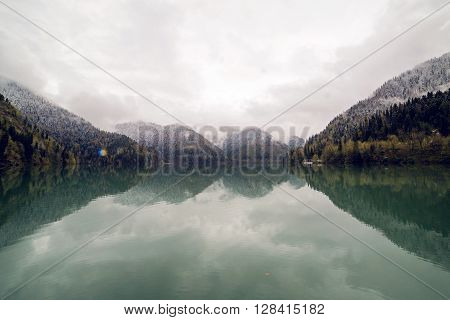 panorama left-to-right Ritsa lake in the spring morning, with clouds and blue water