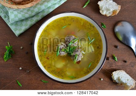 Vegetable soup with meatballs on the wooden background