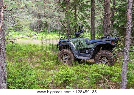NOVGOROD REGION RUSSIA - JULY 9 2015: The modern quad bike parked at the forest in summer day