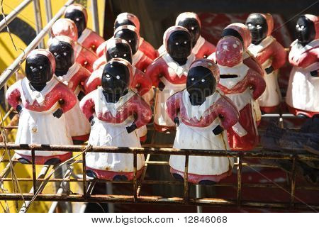 Collection of Aunt Jemima statuettes on shelf.