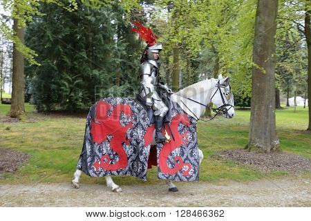 Harcourt France - April 23 2016: An unidentified man in a suit of armour is riding his horse to a mediaeval jousting tournament on Apr. 23 2016 in Harcourt France. It takes place in front of the castle Harcourt in Harcourt France