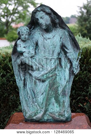 URSBERG, GERMANY - JUNE 09: Virgin Mary with baby Jesus, cemetery in Ursberg, Germany on June 09, 2015.