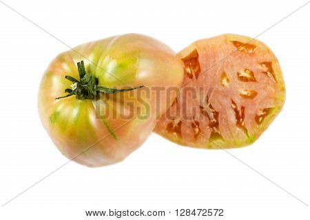 Near ripe ox heart tomato Solanum lycopersicum showing many small seed compartments called locules and a nice pink flesh.