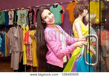 Young woman choosing clothes on a rack in a showroom