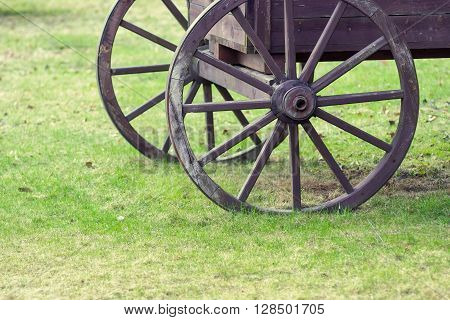 closeup fragment of the ancient wooden animal-drawn vehicle with spoke wheels