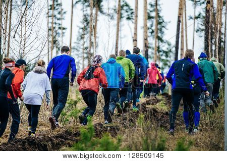 Ekaterinburg Russia - April 24 2016: large group of athletes runners running uphill in woods during a Mountain marathon "UMRU-2016"