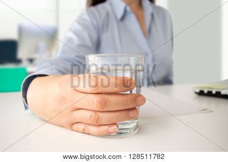 woman working at the laptop and drinking fresh mineral water at the office