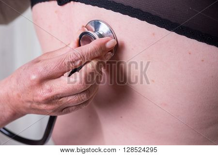 female doctor is listening to lunge of female patient