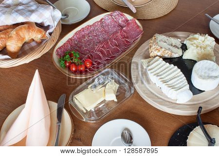 Different types of cheese on the table. Homework healthy breakfast. Diet food. Breakfast for children. Well-laid wooden table.