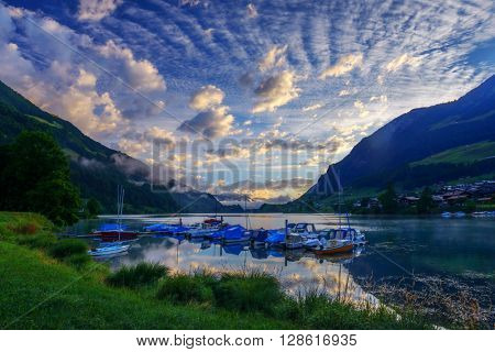 Amazing view of the Lungerersee lake with yachts in the morning mist. Lungern village, Switzerland, Europe.