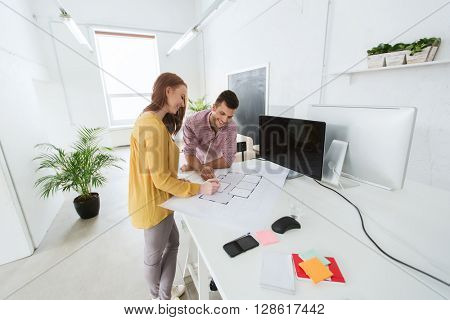 business, startup, architecture and people concept - happy creative architect team or students with blueprint and computer working at office
