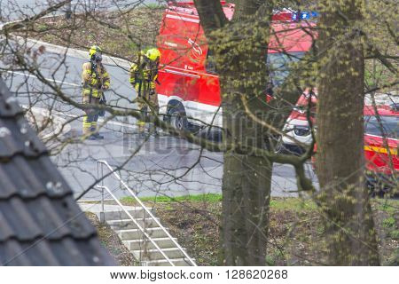 HEILIGENHAUS NRW DEUTSCHLAND - APRIL 08 2016: Firefighters in action in Heiligenhaus Germany firefighters with breathing masks before fire truck.