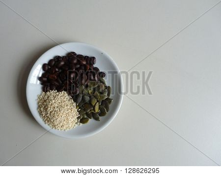 Gourd And Sesami Seed With Coffee Beans On A White Plate