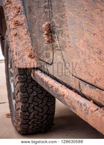 Close up of off-road vehicle covered in red mud