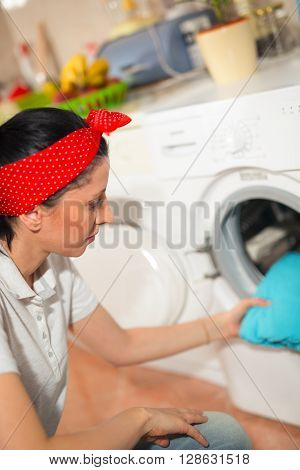 Young woman has a laundry day at home she takes the laundry out of your washing machine