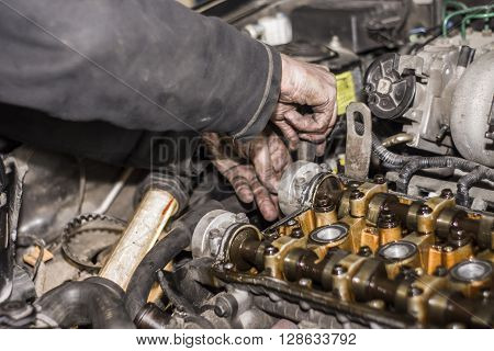 Hands Repairing A Car Engine With A Wrench