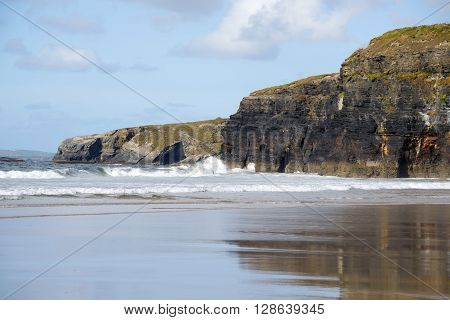 beautiful soft waves break on the beach cliffs at ballybunion
