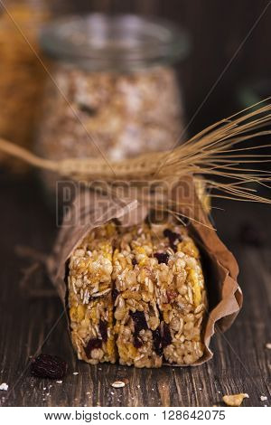 Stack of cereal bars with oat, cranberry, nuts and corn flakes over wooden table