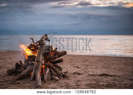 Bonfire At The Beach With Dramatic Clouds