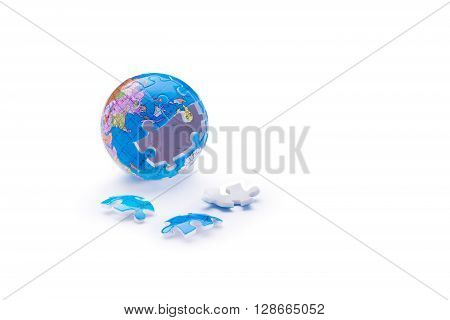 Unfinished globe jigsaw puzzle with three pieces laying down on white background
