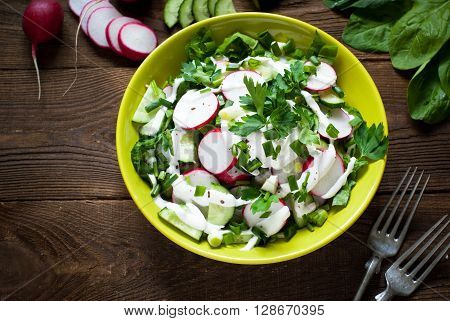 Green salad with radish spinach cucumber and greens with yogurt sauce. Uzeful and healthy food.