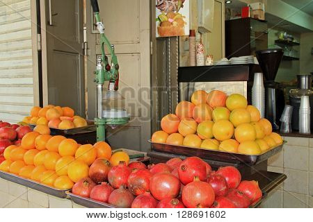 An open air drink stand with oranges and pomegranates in the Christian quarter of Old Jerusalem, Israel.  Also known as the Muristan.