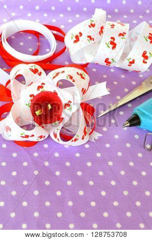 Beautiful bright bow of ribbon, children hair accessory, ribbon set, scissors, glue gun