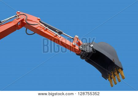 New excavator bucket on blue sky. Hydraulics.