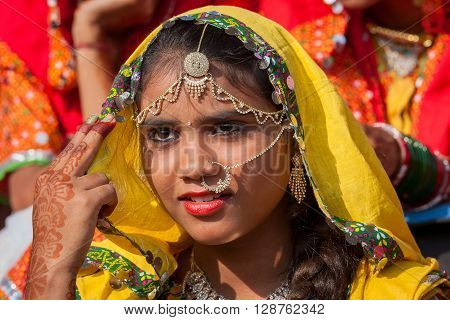 PUSHKAR INDIA - NOVEMBER 21 2012 : Portrait of Indian girl in colorful ethnic attire at Pushkar Camel Mela in Rajasthan India. Pilgrims and camel traders flock to the holy town for the annual fair.