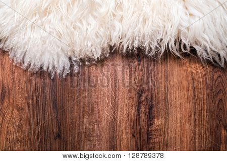 Decorative fur carpet on wood floor background