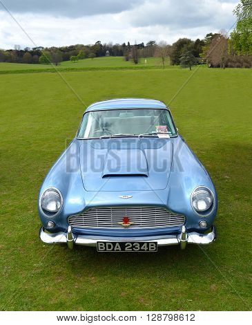 Saffron Walden, Essex, England - April 24, 2016: Classic Light Blue Aston Martin DB5 sports car parked on grass.
