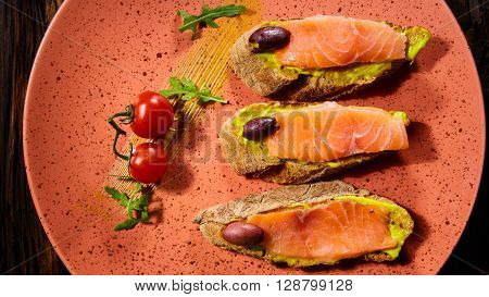 Delicious homemade smoked salmon gluten free canape garnished with tomatoes and olives