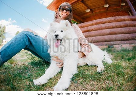 young stylish hipster woman girl playing white kid-skin dog in country side.