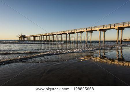 Wide angle shot of Scripps Pier with reflection during sunset in La Jolla, San Diego, California