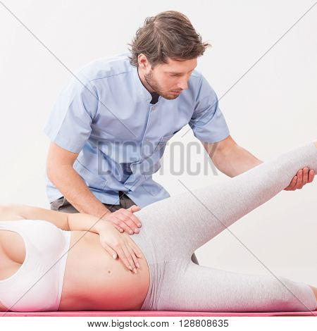 Pregnant Woman Exercising With Physiotherapist