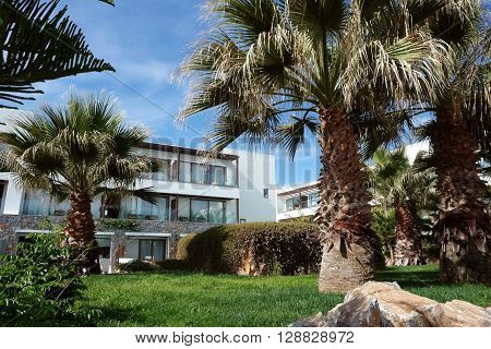 HERAKLION, CRETE, GREECE - MAY 13, 2014: The blue sky modern building with balcones and palms on the terrain of luxury class hotel Grecotel Amirandes on the Mediterranean coast of Crete, May 13, 2014, Greece.