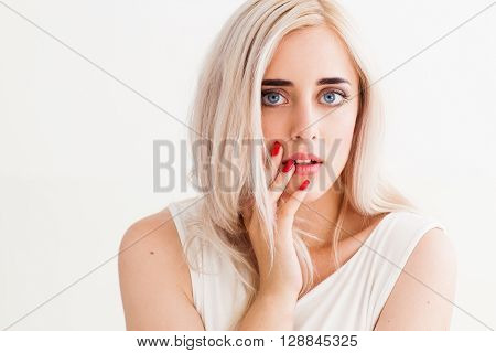 Surprised shoked girl covers her mouth and her eyes wide open. Fashion girl  shows wow on a white background.  Beautiful woman amazed.